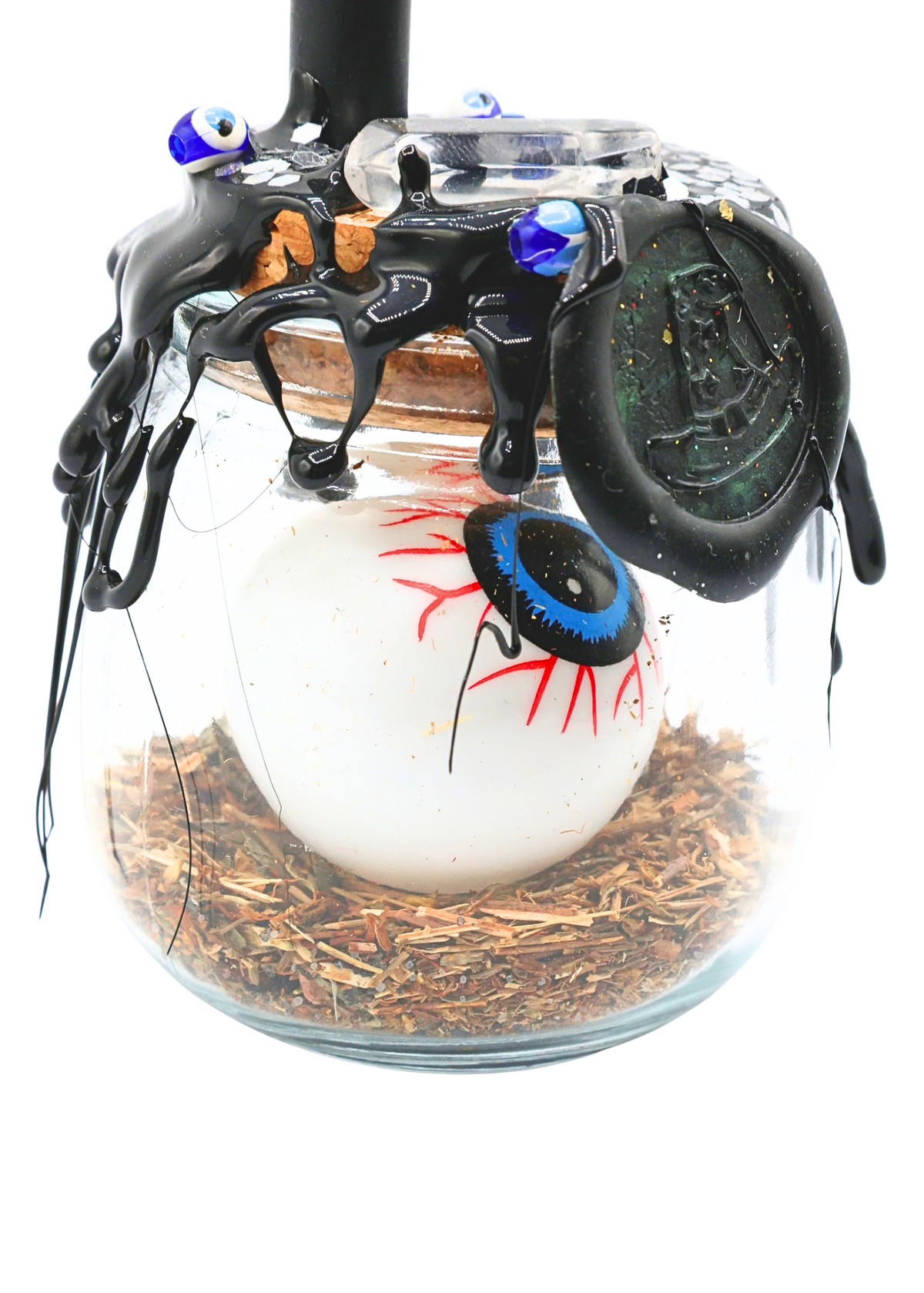 Close-up of Large Protection Spell Jar featuring black wax seal, blue eyeball charm and dried herbs