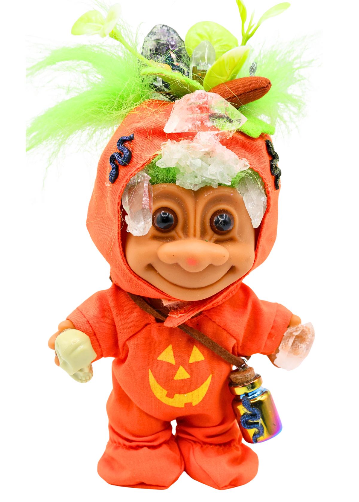 Close front view of Hexley crystal troll sculpture wearing orange jack-o-lantern outfit with quartz crystal accents