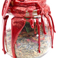 Close-up of Large Love Spell Jar showing sparkling red wax drips and dried herbs inside clear glass