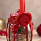 Large Love Spell Jar with red candle, crimson wax seal and dried botanicals on a soft romantic background