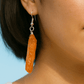 woman wearing orange aura quartz earrings