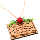 Wooden Ouija board holiday ornament shown at an angle with twine hanger